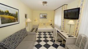 莱茵河畔的纳沙泰尔阿尼卡酒店的客厅配有沙发和书桌。
