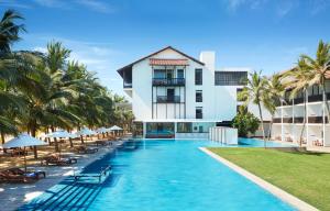 尼甘布杰特维茵酒店集团有限公司的一座棕榈树酒店游泳池和一座建筑