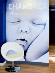 库尔布瓦ibis Budget Courbevoie Paris La Défense的婴儿的海报和白色椅子