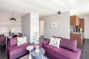 格勒诺布尔格勒诺布尔坦帕洛吉斯公寓式酒店的一间带紫色沙发的客厅和一间厨房