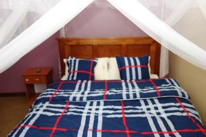 金贾Impala Suites的一间卧室配有一张蓝色和红色条纹的床