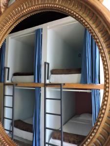墨西哥城胶囊旅舍的镜子反射着两张双层床,配有蓝色窗帘