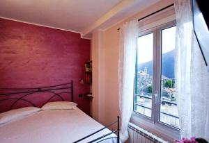 Balestrino阿尔伯格瑟奇旅馆的一间卧室设有一张床和一个大窗户