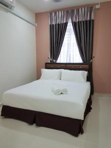 龙运乌米宾馆的卧室配有一张大白色床和窗户