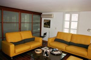 戛纳戛纳阁楼住宿加早餐旅馆的客厅配有2把黄色椅子和桌子