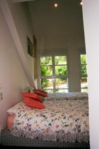 戛纳戛纳阁楼住宿加早餐旅馆的一间卧室配有一张带红色枕头的床和一扇窗户