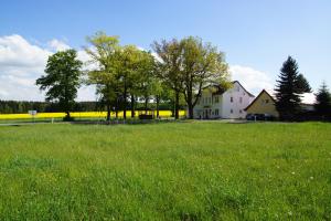 RaumLandpension Bielatal - Raum的绿色草地上的白色房子