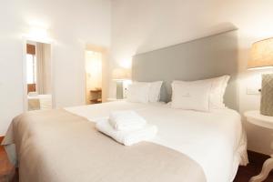 科尔多瓦阿塞特公寓的一张白色的床,上面有两条毛巾