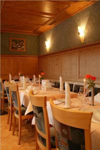 Neubulach狮子酒店的用餐室配有桌椅、蜡烛和鲜花