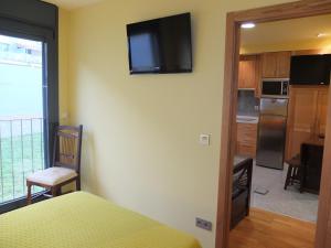 巴约讷Apartamentos Ababides Playa的一间房间,配有一张床和墙上的电视