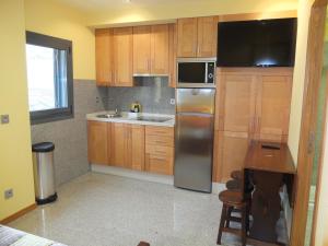 巴约讷Apartamentos Ababides Playa的厨房配有木制橱柜和不锈钢冰箱。