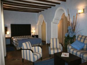 MunébregaLa Casona del Solanar的配有床、椅子和桌子的酒店客房