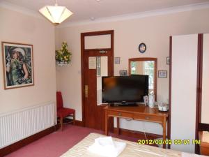 彼得伯勒索普洛奇酒店的客厅配有电视和带电视的桌子。