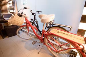 马德里珀蒂宫赛珀格兰维尔酒店的一辆红色自行车停在另一辆自行车旁边,车上装有篮子