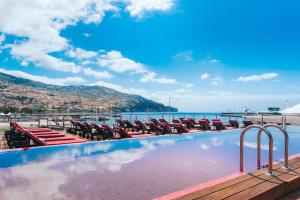 丰沙尔丰沙尔CR7佩斯塔纳酒店&度假村 的一个带躺椅的游泳池和海洋