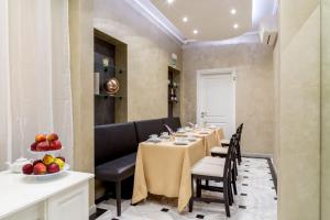 罗马弗拉迪纳华丽套房旅馆的用餐室配有长桌子、椅子和水果