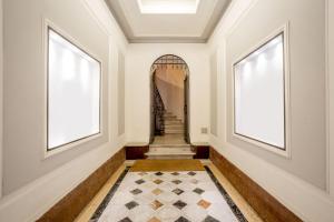 罗马弗拉迪纳华丽套房旅馆的走廊设有楼梯,配有两扇窗户和地毯