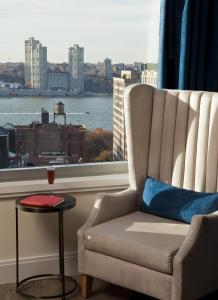 纽约Arthouse Hotel的窗户房间里一张椅子和一张桌子