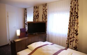弗雷兴罗卡姆酒店的一间卧室配有一张床和一台平面电视