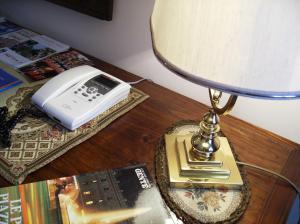 苏尔莫纳圣嘉勒住宿加早餐酒店的一张桌子,上面有台灯,电话和一本书