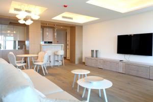 普拉加德阿罗Cosmo Apartments Platja d'Aro的客厅配有桌子和平面电视