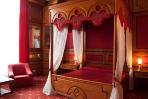 卢戈日Hotel Dacia的一间卧室配有一张天蓬床和一把椅子