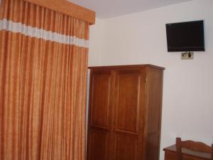 莫塞永芭堤雅酒店的一间设有窗帘、电视和橱柜的房间