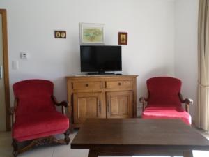 索姆勒兹Gremin的客厅配有2把红色椅子和电视