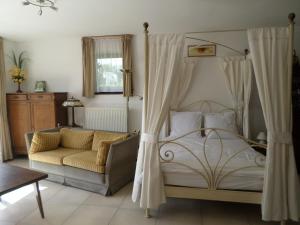 索姆勒兹Gremin的一间卧室配有天蓬床和沙发