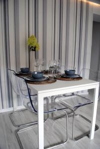 科沙林Apartament 1Maja的一张带椅子的白色桌子和酒杯