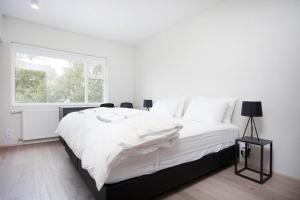 雷克雅未克北欧城市花园酒店的白色的卧室设有一张大床和一个窗户