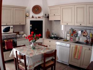 孔韦尔萨诺Villa Maria的厨房配有一张桌子,上面放着花瓶