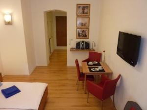 杜塞尔多夫莱辛公寓 的客房设有桌子、电视和桌椅。