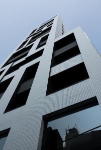 东京涩谷格兰贝尔酒店的一座高大的白色建筑,设有黑色窗户
