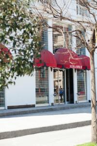 萨姆松内巴皇家酒店的大楼前的一间餐厅,配有红色遮阳伞