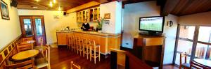 坎波斯杜若尔当Hotel Sagres的餐厅设有酒吧、椅子和电视