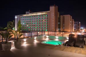 马塞约Amenit Hotel的夜间酒店屋顶的游泳池