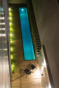 马塞约Amenit Hotel的游泳池,带椅子和灯