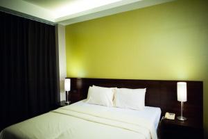 曼谷班西隆第3巷酒店的一间卧室设有一张大床和绿色的墙壁
