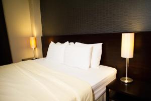 曼谷班西隆第3巷酒店的酒店客房配有带白色床单和枕头的床。