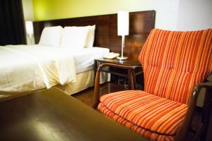 曼谷班西隆第3巷酒店的配有一张床和一把椅子的酒店客房