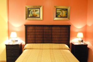 圣玛丽亚港皮诺玛尔酒店的一间卧室配有一张带两个床头柜和两张墙上照片的床。