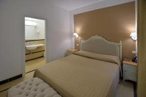 锡拉库扎加加略酒店的一间卧室配有床、水槽和镜子