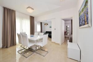 比比涅Luxury Apartment 1 Villa Arta的白色的用餐室配有白色的桌椅