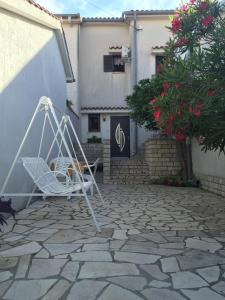 奥米沙利Apartment Melina的石质庭院上的白色椅子