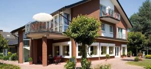 巴特塞森多夫弗洛勒霍夫酒店的一座大砖砌建筑,设有阳台和一棵树