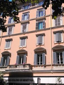 罗马CiaoRoma!的一座大型粉红色建筑,设有窗户和阳台