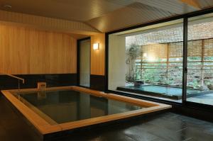 宫岛伊娃索酒店的一个带大窗户的房间内的游泳池