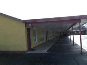兰伯顿Budget inn的黄色的建筑,旁边设有一条长长的走廊