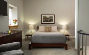 霍利岩壁酒店 的一间卧室配有床、两张桌子和一台电视